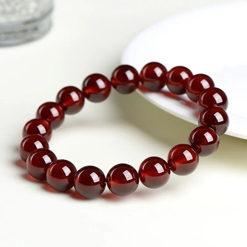 Natural orange red garnet ball bracelet with ruyi charm showing crystal construction and spherical gemstones