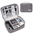 Black electronics organiser case open to show mesh pockets, elastic loops and removable padded dividers inside.