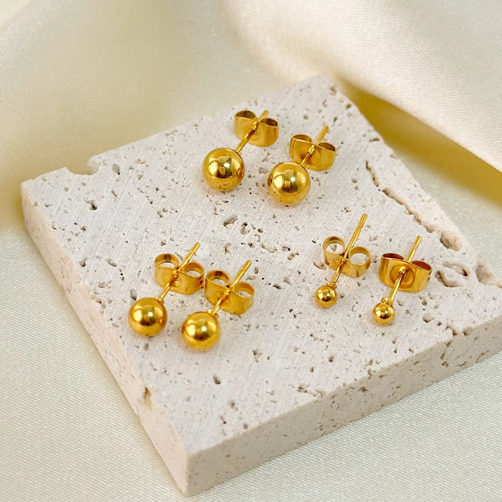 Stainless steel 18K gold ball stud earrings in simple round geometric design on a white background.