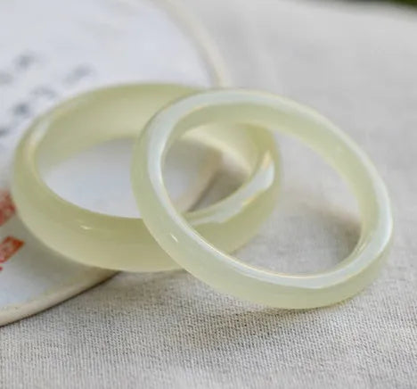 Ice-like silk jade round bar bracelet on neutral background showing smooth surface and circular shape