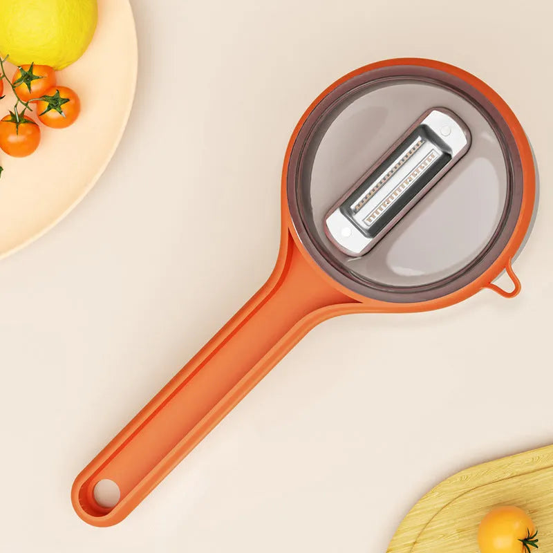Kitchen multi-functional peeler with bucket storage in light green plastic on a clean countertop
