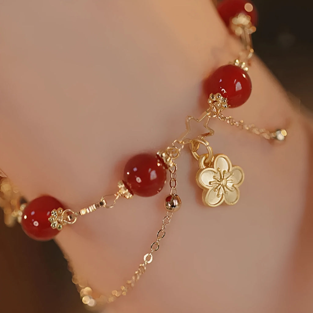 Red agate double layer bracelet with floral and peach blossom charms on adjustable band
