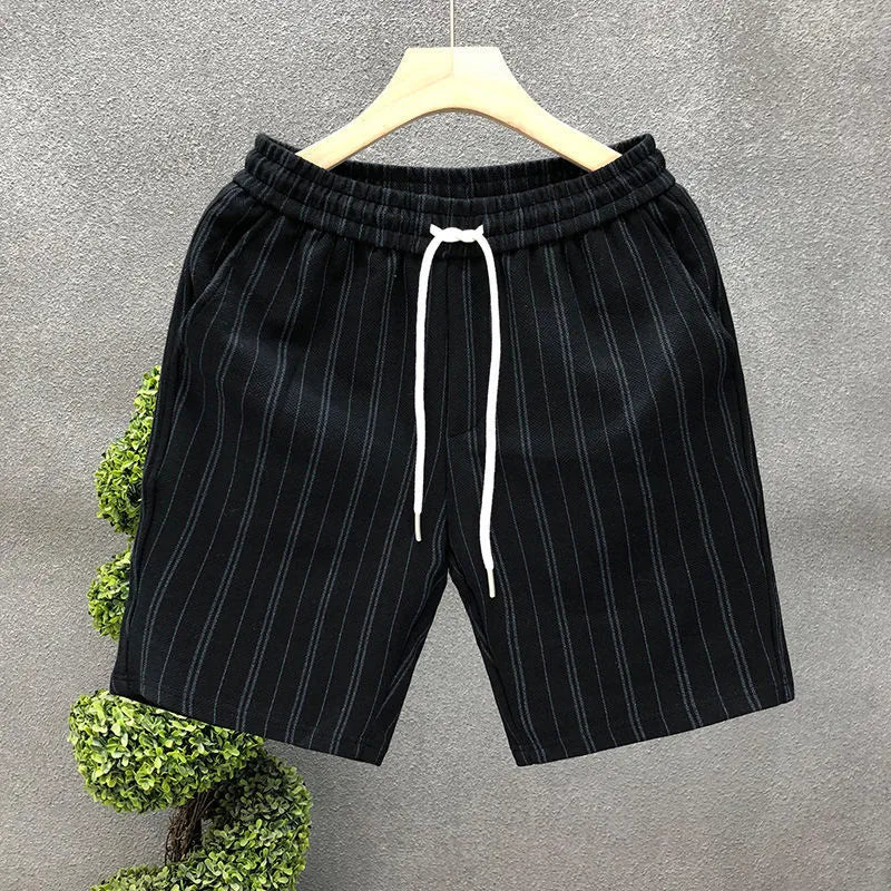 Man wearing black and white striped fleece-lined casual shorts with an elastic waistband.