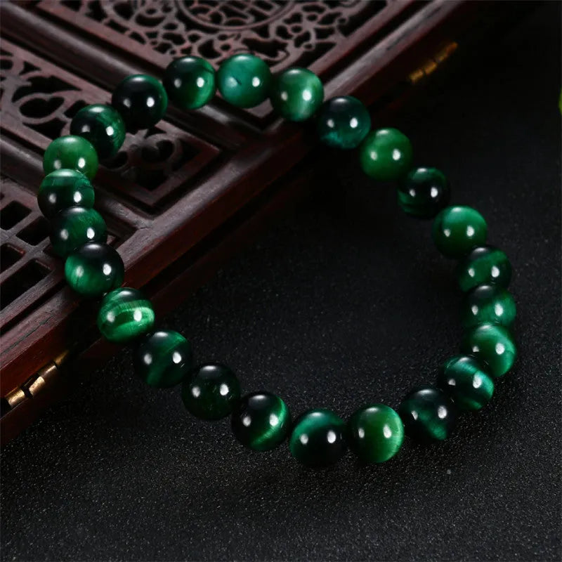 Green tiger eye stone bracelet with geometric polished beads showing banded natural patterns