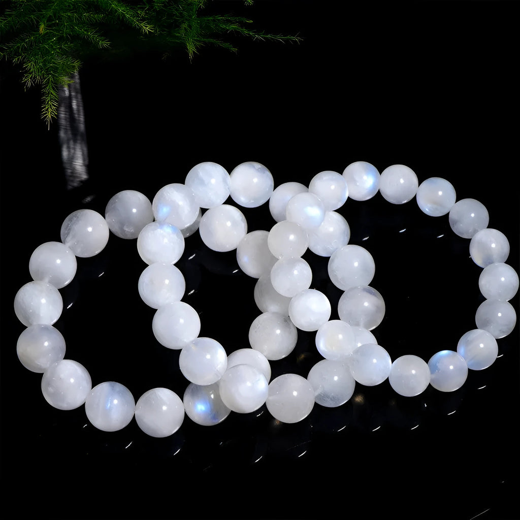 White polished moonstone bead bracelet with blue moonlight sheen, showing round geometric beads.