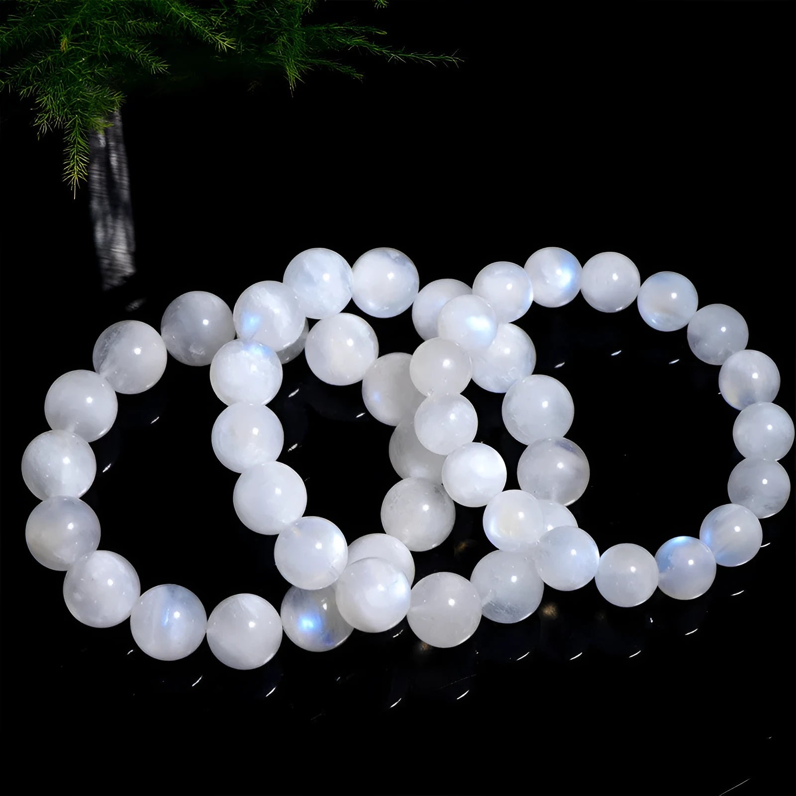 White polished moonstone bead bracelet with blue moonlight sheen, showing round geometric beads.