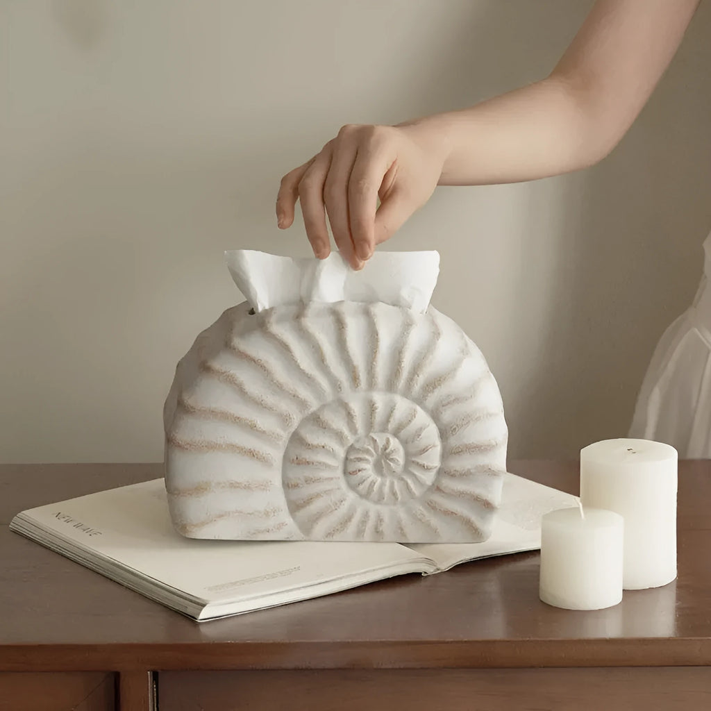 White conch shell shaped resin cover for a rectangular tissue box with a slot for tissue dispensing.