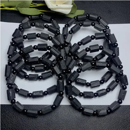 Natural black tourmaline rough stone bracelet unisex 10mm bead size on plain background