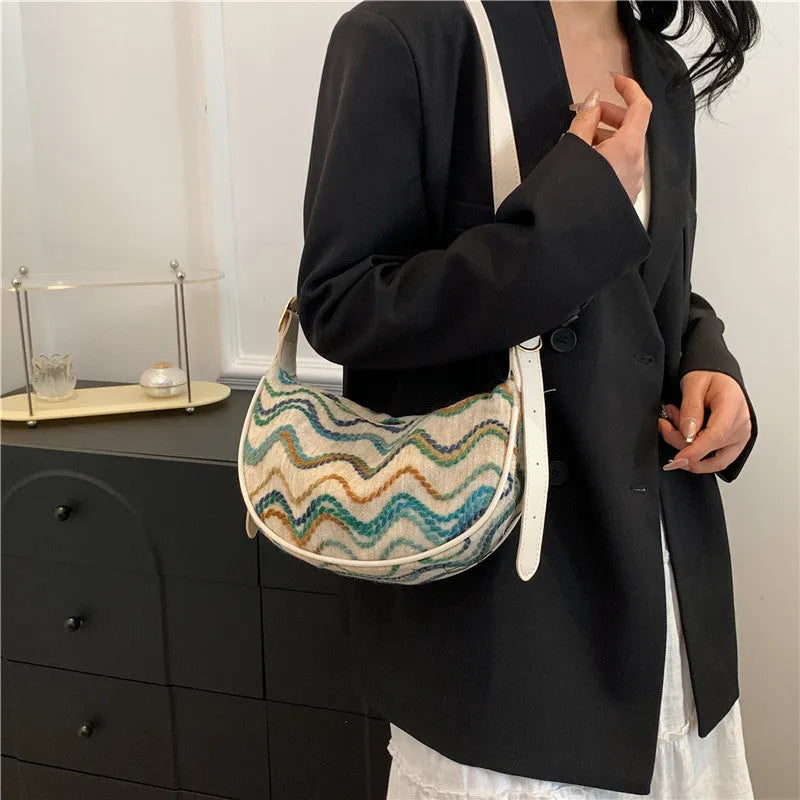Women's knitted straw woven crossbody bag showing woven texture and internal phone and document pockets