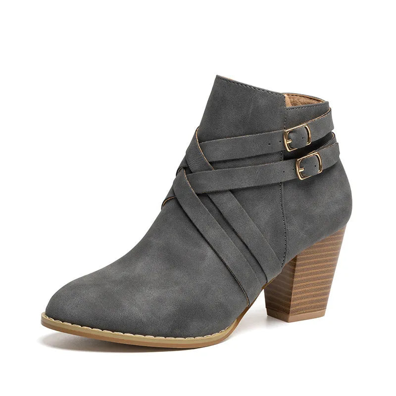 Women's grey short boot with 7cm heel, side zipper, and belt buckle detail on a rubber sole.