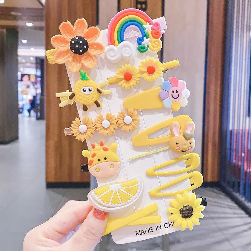 14-piece toddler hair accessories set on display including rainbow barrettes, fruit clips, and butterfly pins in bright colours