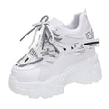 Women's white mesh platform trainers with cross strap and rubber sole showing side profile