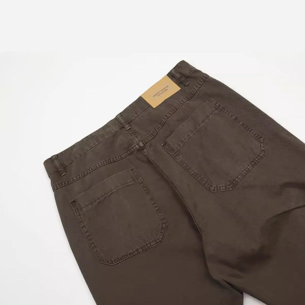 Men's brown straight-leg cotton trousers showing high-waist design with wide leg opening and zipper fly
