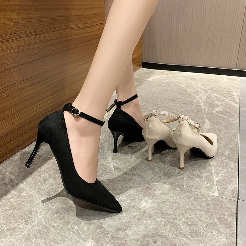 Women's black stiletto heel pump shoes with a buckle detail on the upper.
