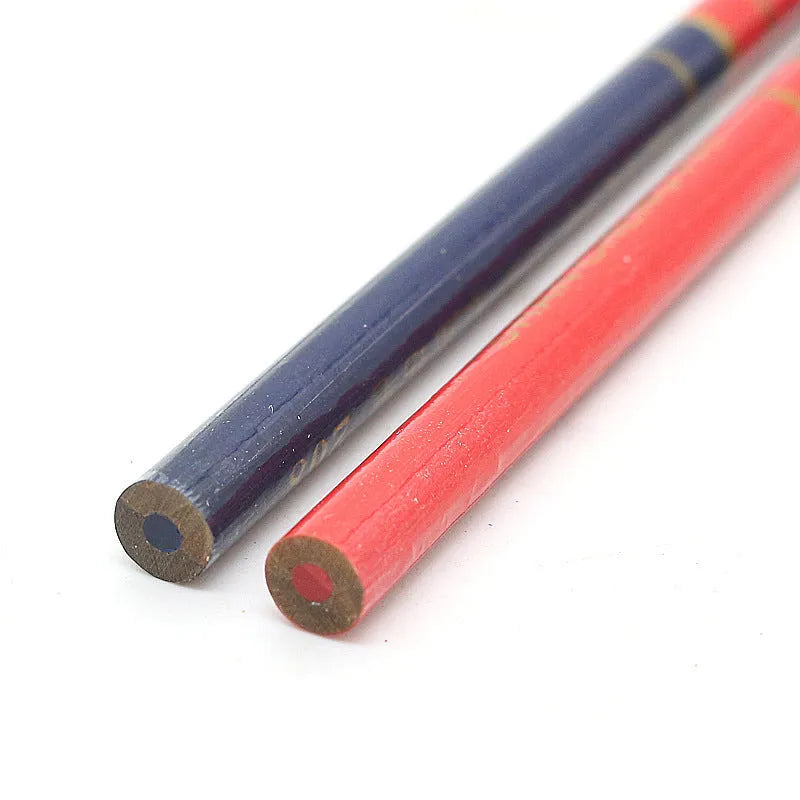 Ten red and blue round wooden carpenter pencils for marking, laid out on a work surface.