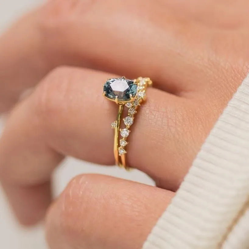 Gold electroplated flower-shaped alloy ring with a central green zircon stone.