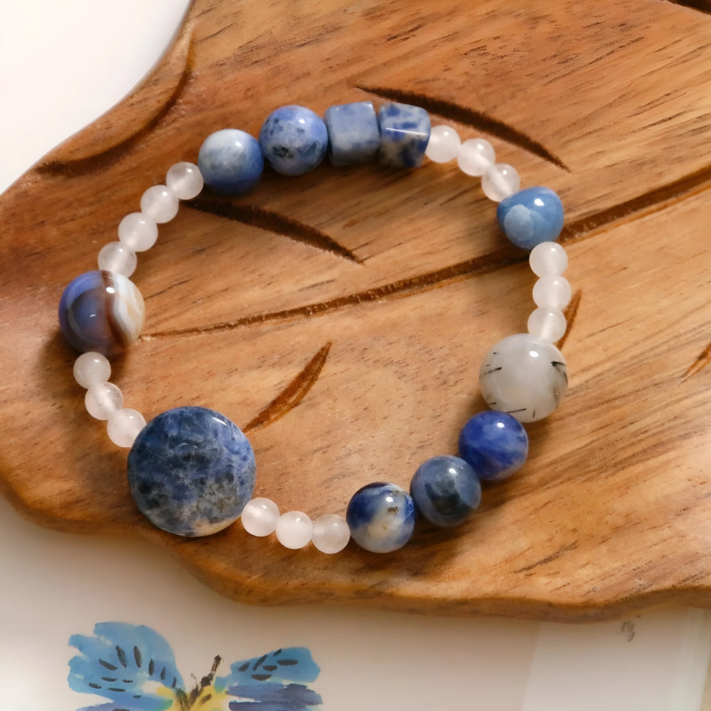 Natural blue point stone and black hair crystal agate hand-woven unisex bracelet with round and oval beads on white background