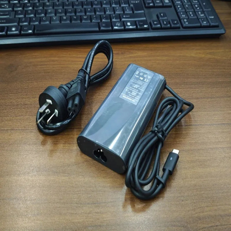 Black 65W USB-C laptop power adapter with multiple international plug attachments