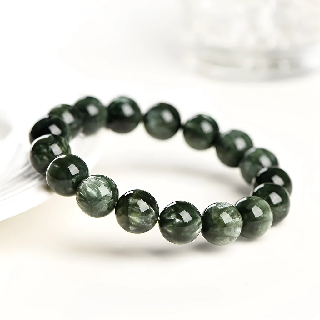 Natural green dragon crystal round bead bracelet with ruyi design on a wrist.