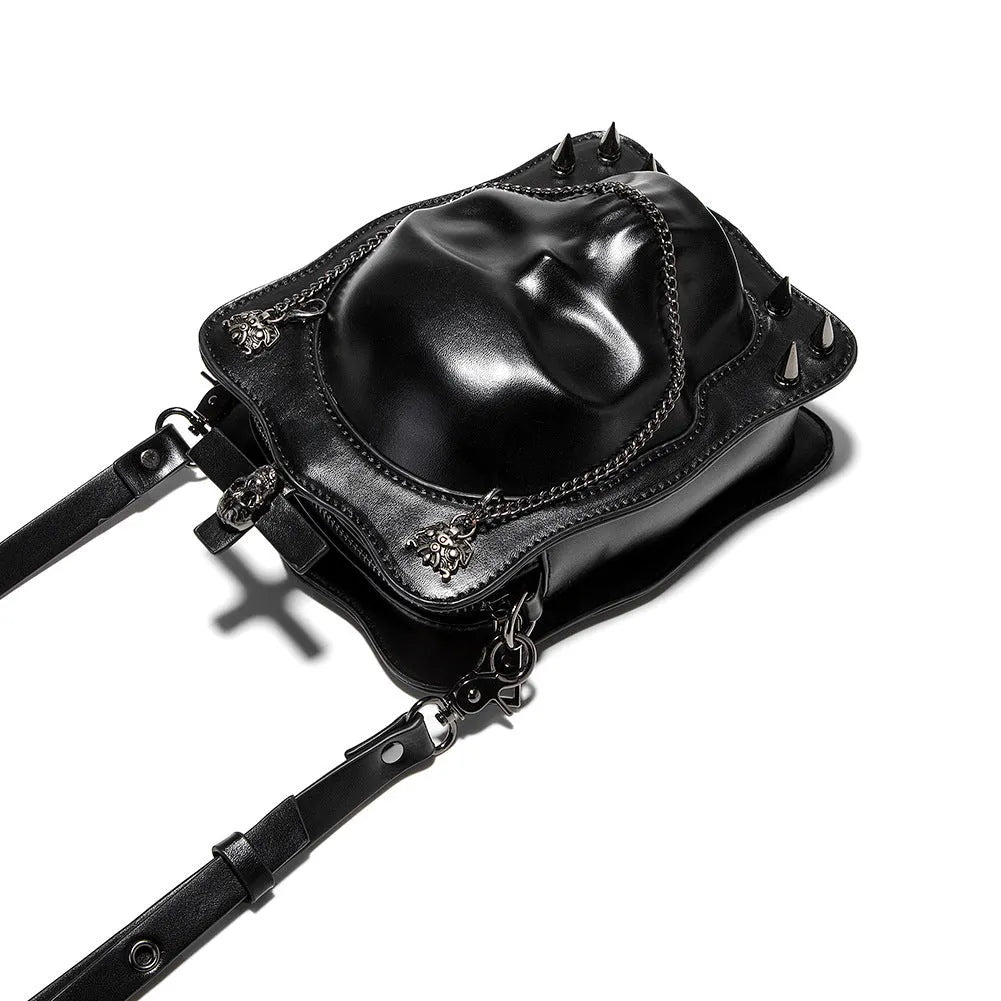 Black mini square crossbody bag with embossed skull design, chain accents, and zipper closure