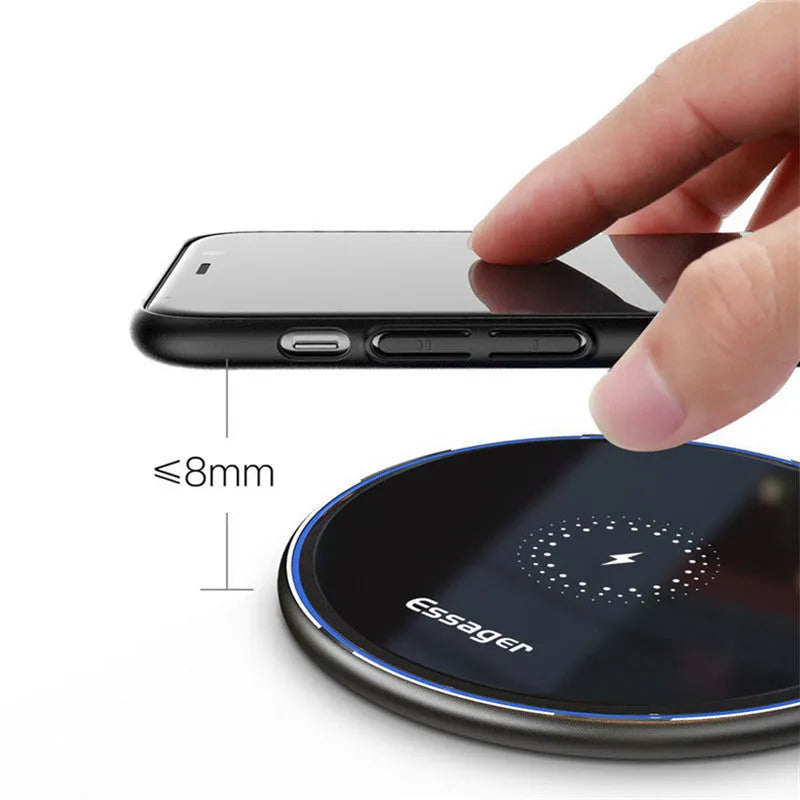 Black or white 15W Qi wireless charging pad on a table with LED light and phone charging.