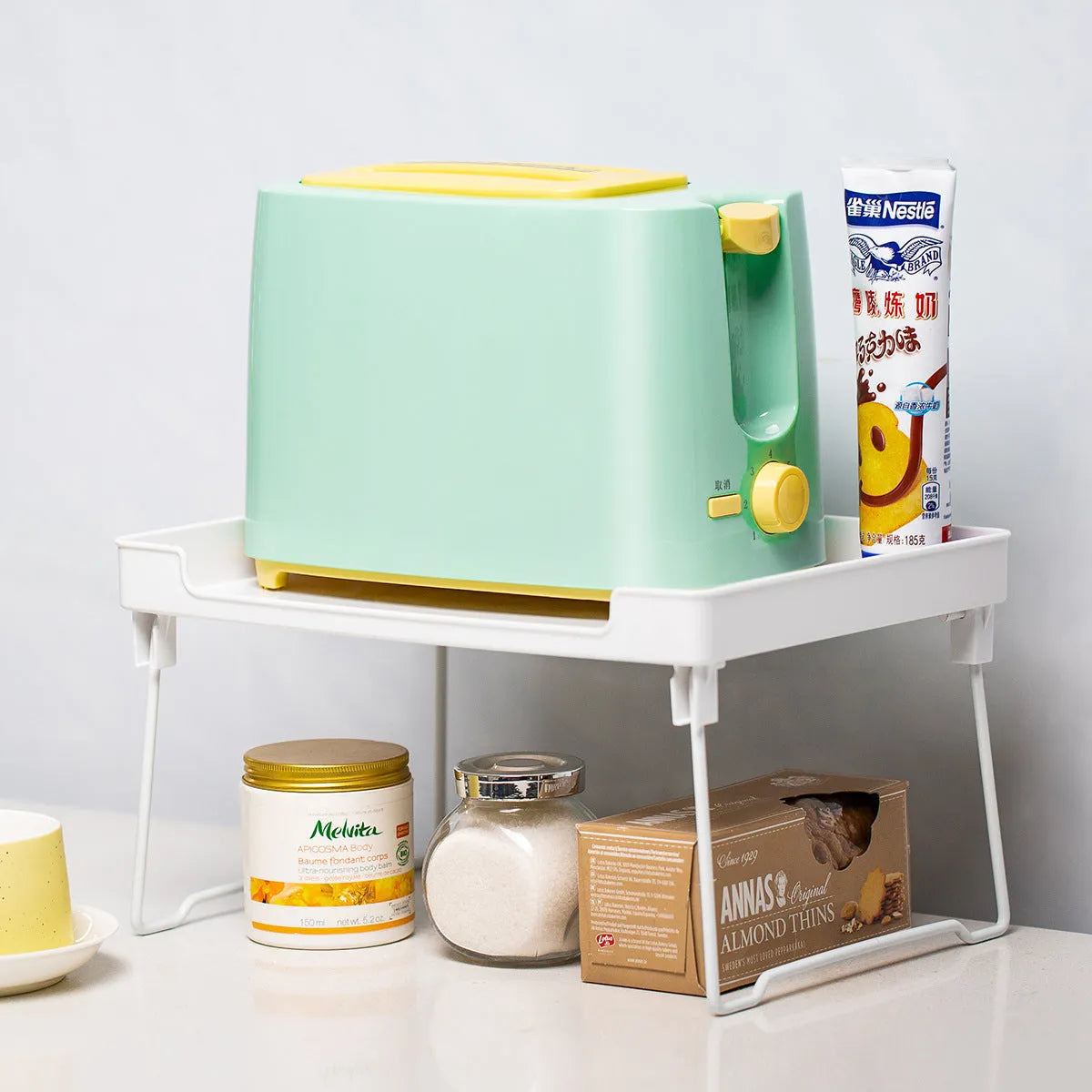 Plastic kitchen supplies rack in transparent colour on a countertop holding spice jars and small bottles