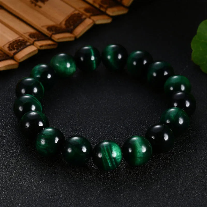 Green tiger eye stone bracelet with geometric polished beads showing banded natural patterns