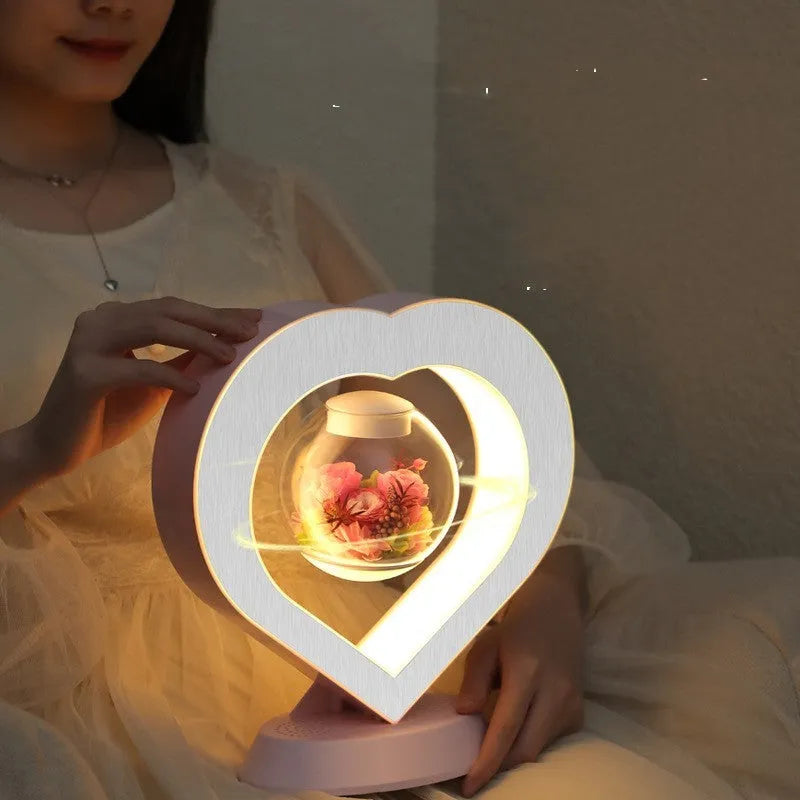 Magnetic levitation heart lamp with preserved pink rose floating above a stable stand, LED night light, home decor
