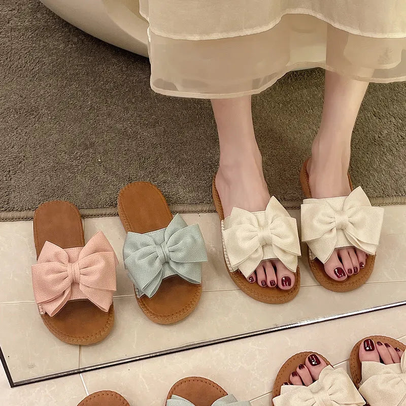 Women's slip-on suede sandals with bow, soft flat heel, beige colour, on casual setting