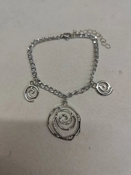 Women's spiral donut jewellery set showing matching gold necklace, bracelet, and earrings with geometric circle design