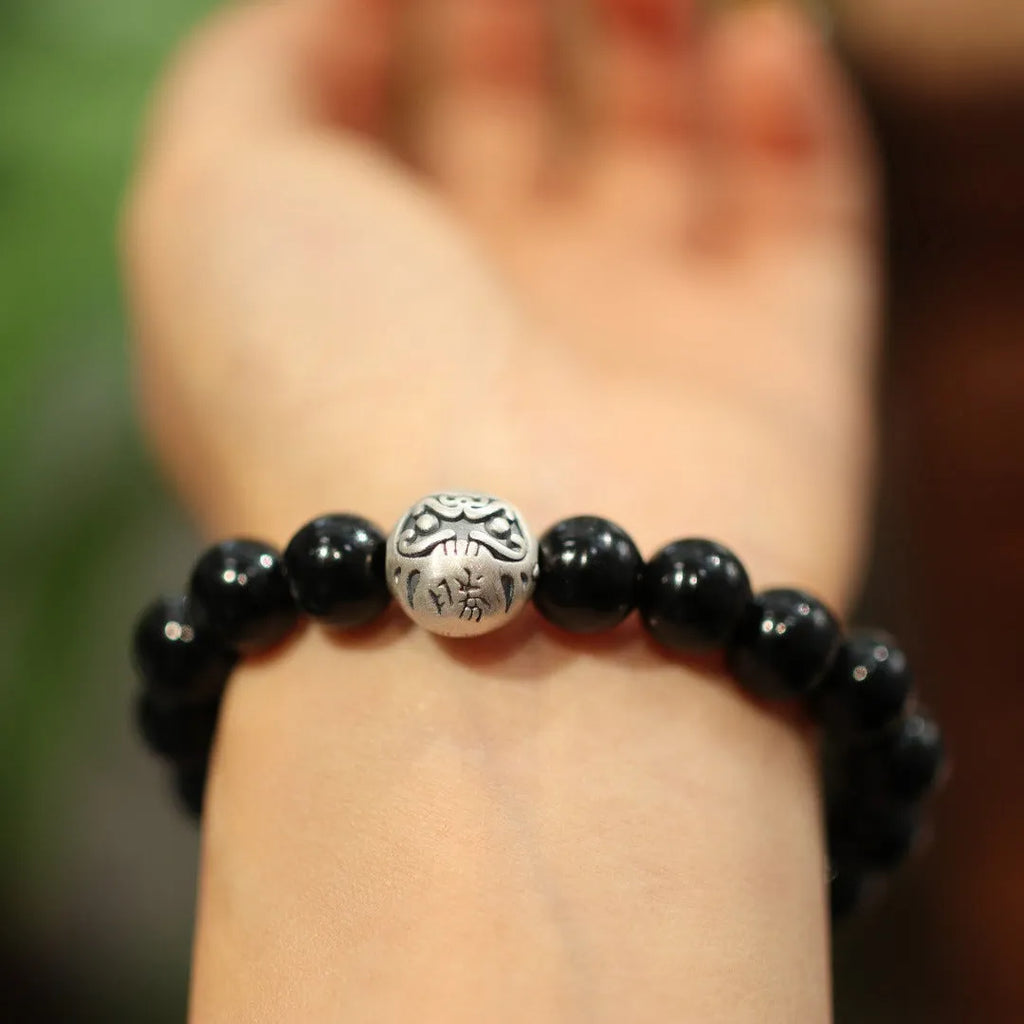 Close-up of a women's bracelet with large 10mm black agate beads on a shiny silver alloy chain in a Chinese style.