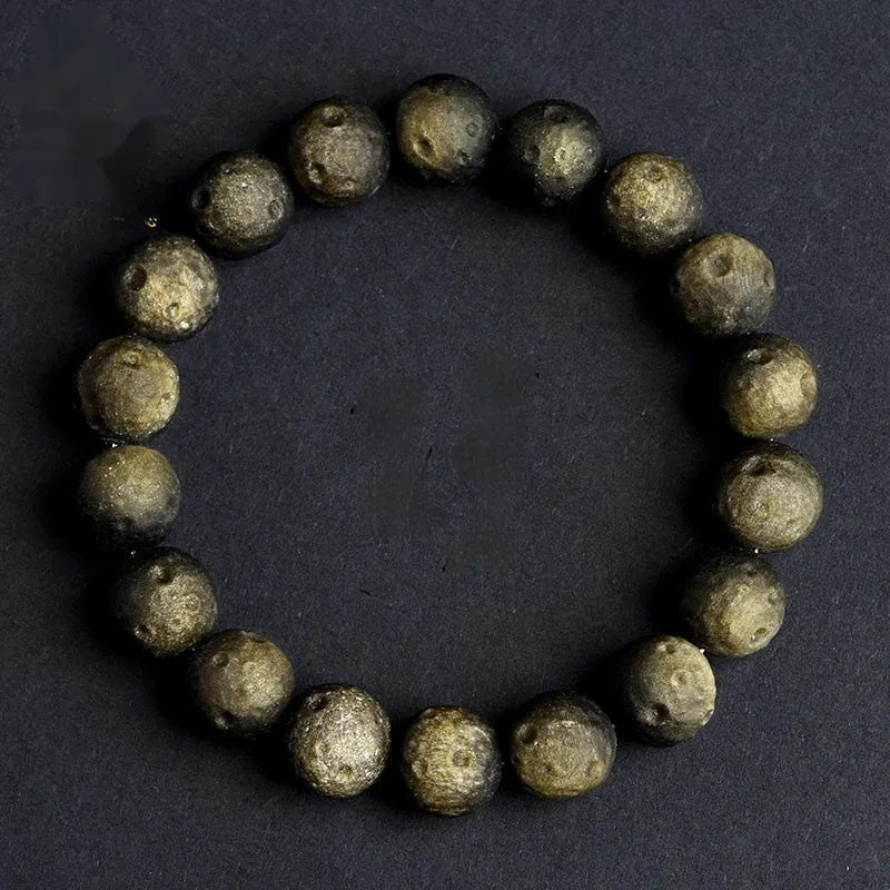 Natural crater ball obsidian bracelet with polished spherical beads showing textured meteorite-style patterns