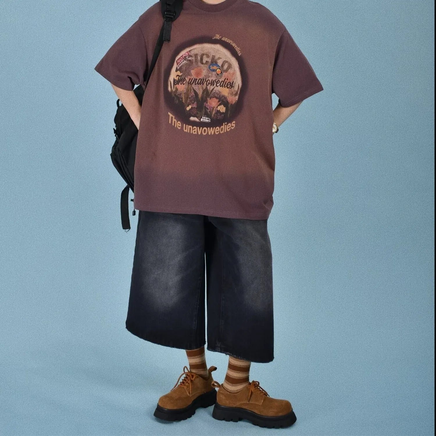 Men's loose straight-cut denim shorts in blue shown on a model, featuring a fifth-pants length.