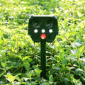 Green solar-powered ultrasonic dog repeller with LED lights for outdoor animal deterrent.