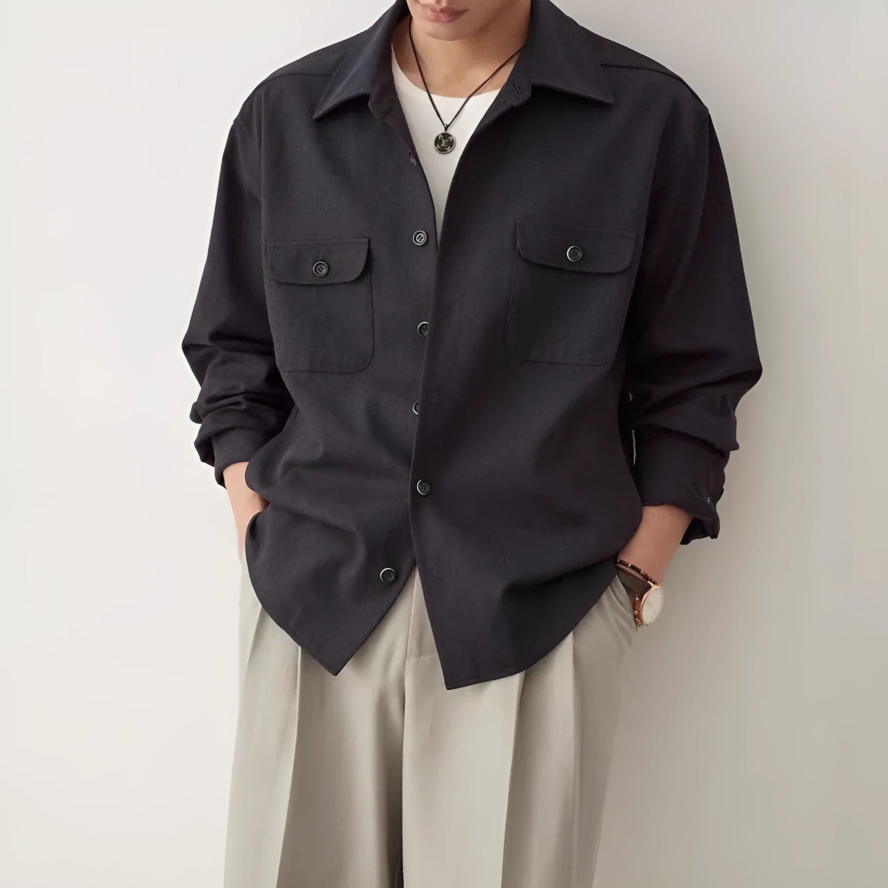 Men's light sand rice coloured cotton shirt with lapel collar and long sleeves laid flat.
