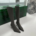 Black pointed toe women's below-the-knee stiletto boots with a back zipper on a white background