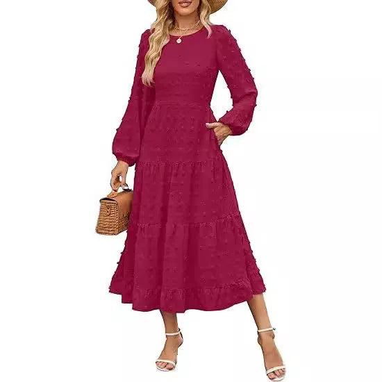 A woman wearing a beige high waist long sleeve dress with ruffle details on a autumn day.