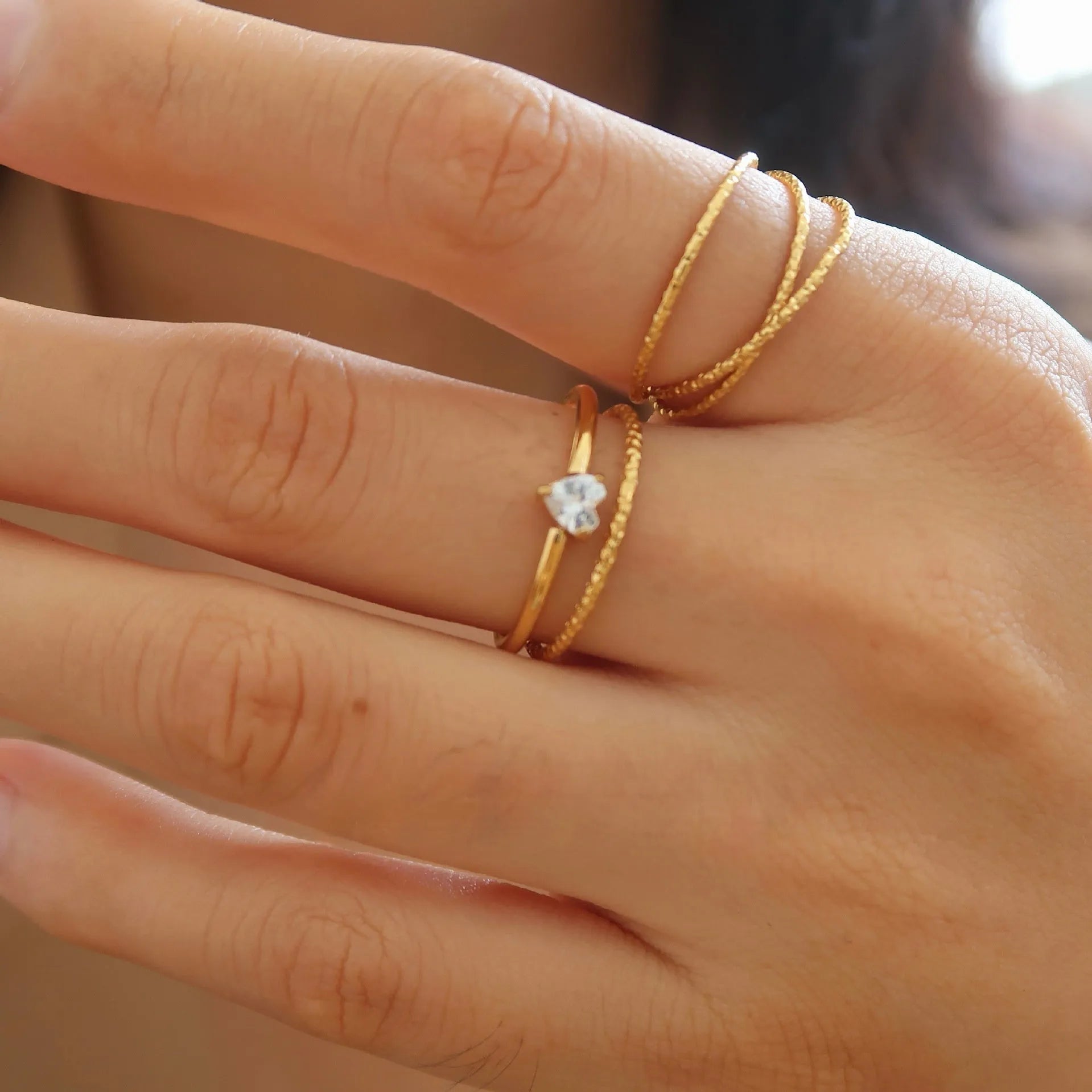 Golden stainless steel ring with heart shape on oval band, shown in size options 5 through 8