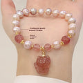 Women's natural freshwater pearl bracelet with light pink pearl, strawberry quartz, and fox charm on white background