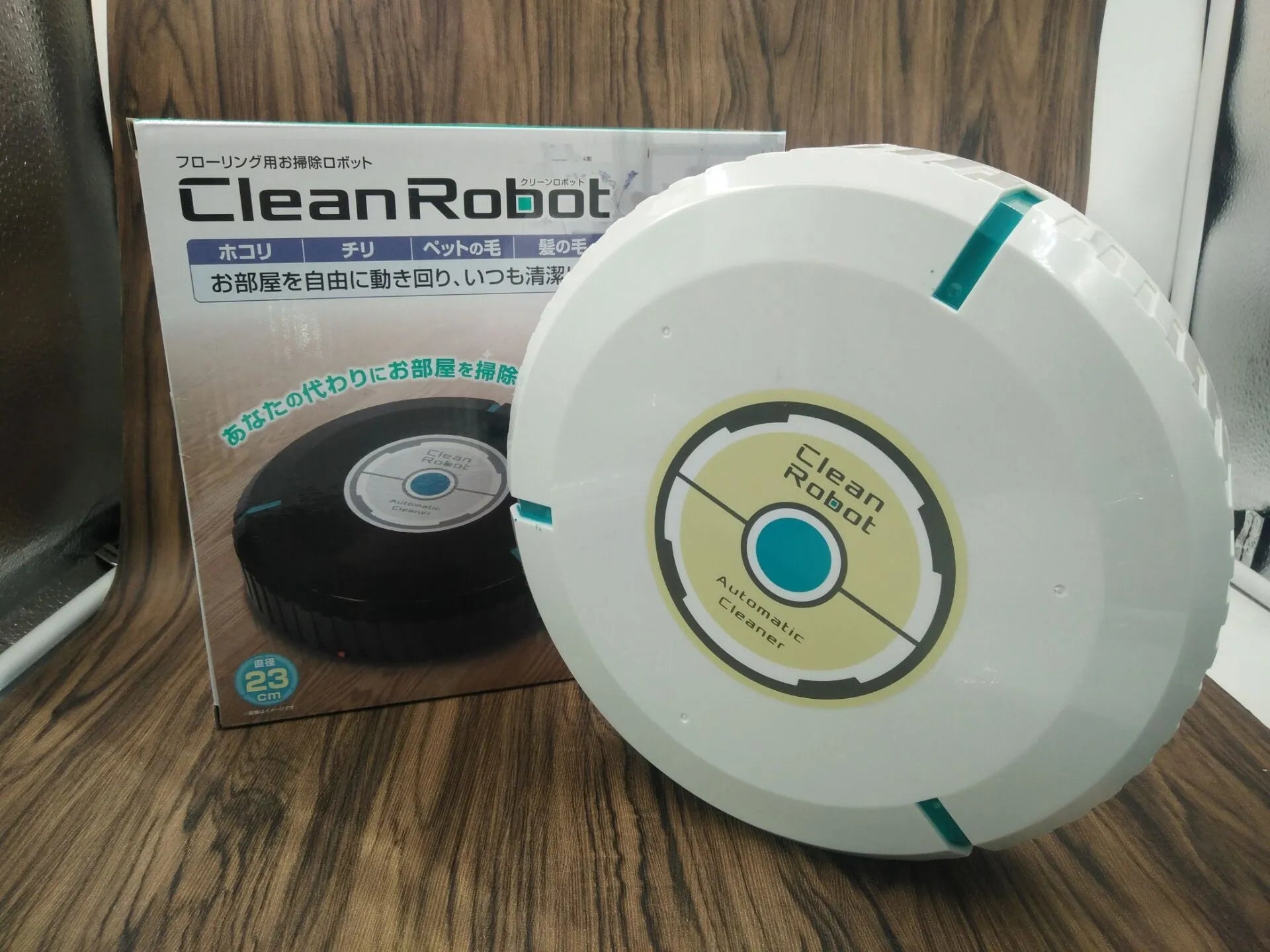 Black and white ABS robot vacuum cleaner on a wooden floor