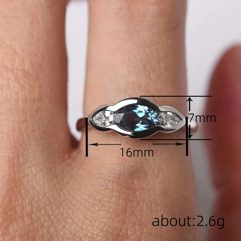 Women's geometric ellipse ring in white gold tone with inlaid zircon detailing, showing contemporary design
