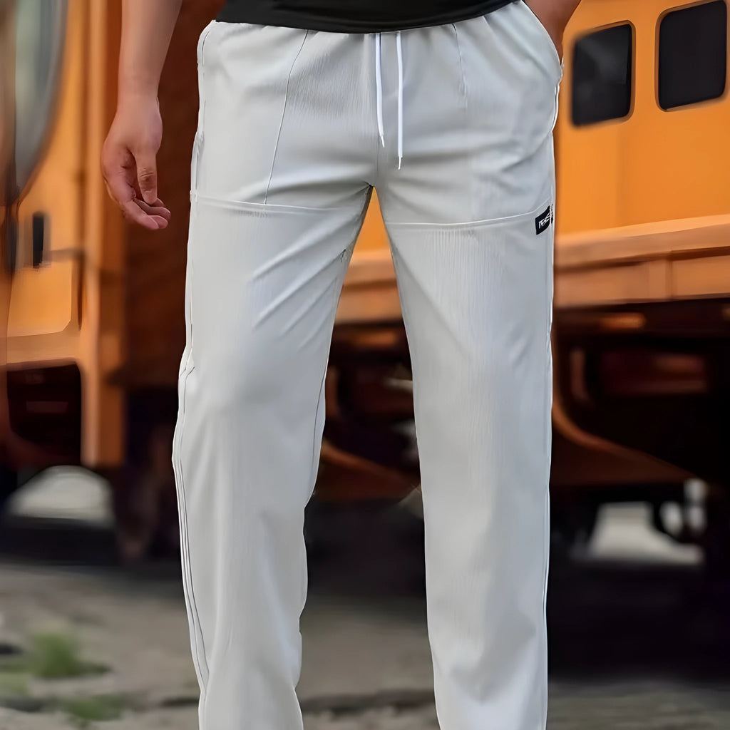 Men's polyester trousers in light grey, shown folded, for casual spring and autumn wear.