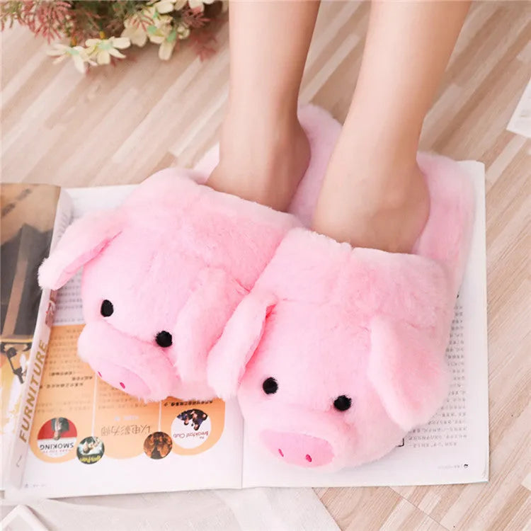 Pair of soft pink pig-shaped plush slippers with a cute animal face design.