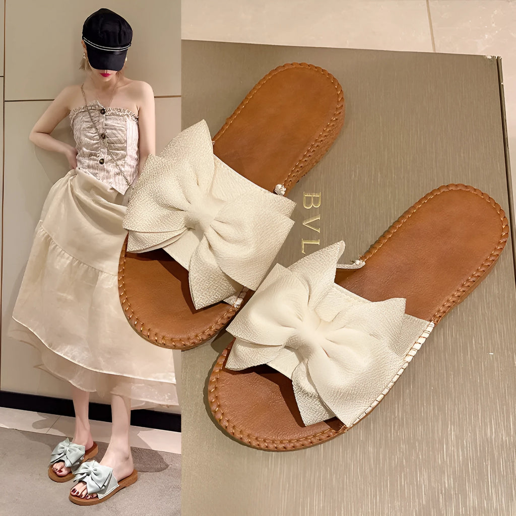 Women's slip-on suede sandals with bow, soft flat heel, beige colour, on casual setting
