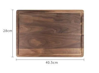 Black walnut wood double-sided cutting board with juice groove and side handle on kitchen counter