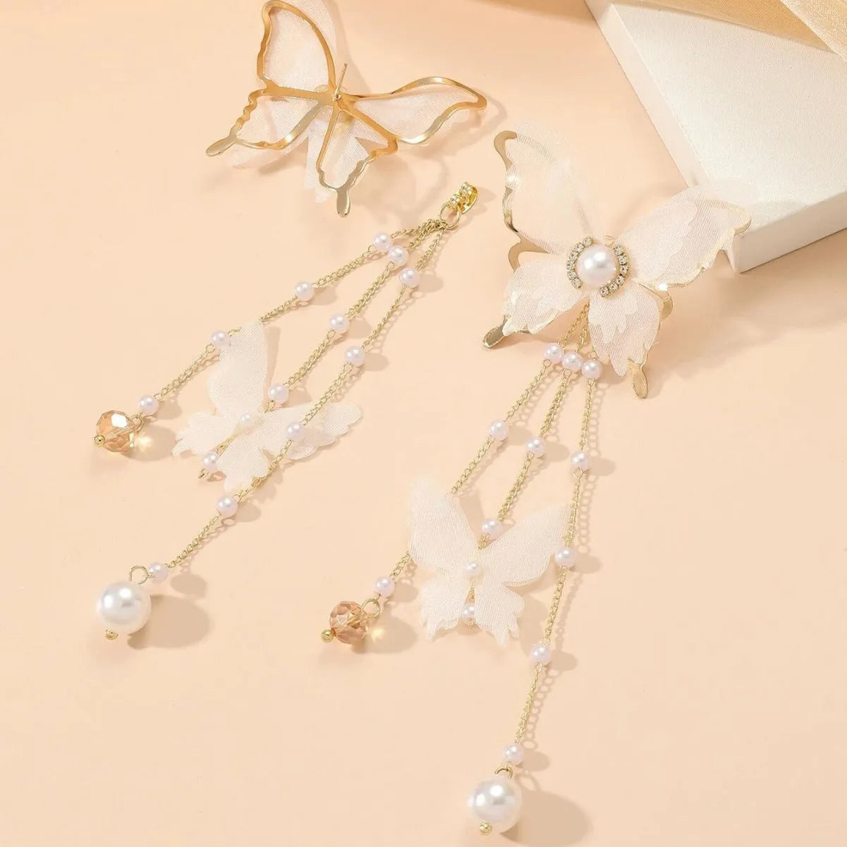 White butterfly earrings with pearl and rhinestone details and tassel design