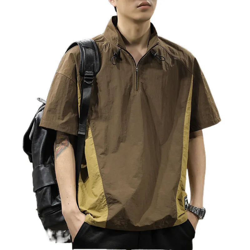 Man wearing a brown short-sleeved shirt with a half-zipped stand collar, showing the loose fit.