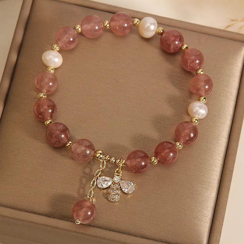 Women's beaded bracelet with strawberry quartz stones, freshwater pearls, and zircon accents on alloy.
