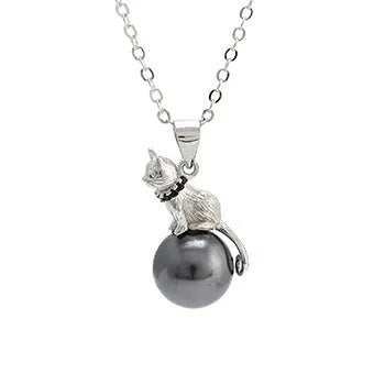 Close-up of a sterling silver cat pendant necklace on a dark background, showing the detailed charm.