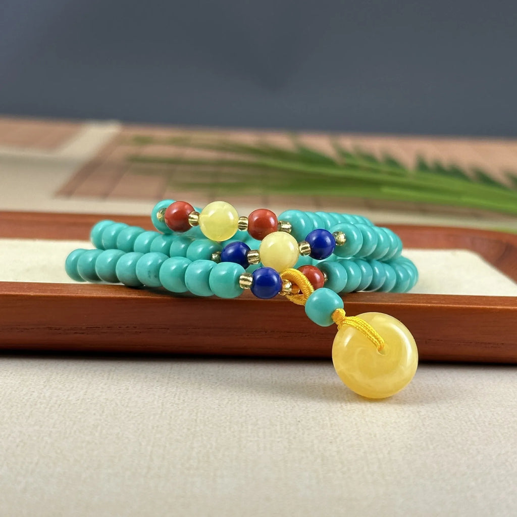 Turquoise lucky pendant necklace with hand-woven mesh flower design on an adjustable ball bead chain.